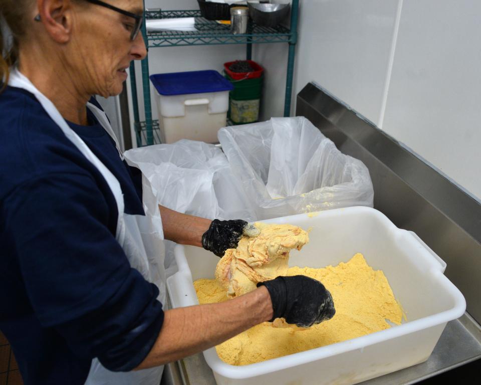 Rhonda Gorman, a kitchen staffer at the AC&T Travel Plaza on Hopewell Road, puts chicken into the company's breading. Hagerstown-based AC&T was picked by Herald-Mail readers recently as having the best gas station food in the Tri-State region.