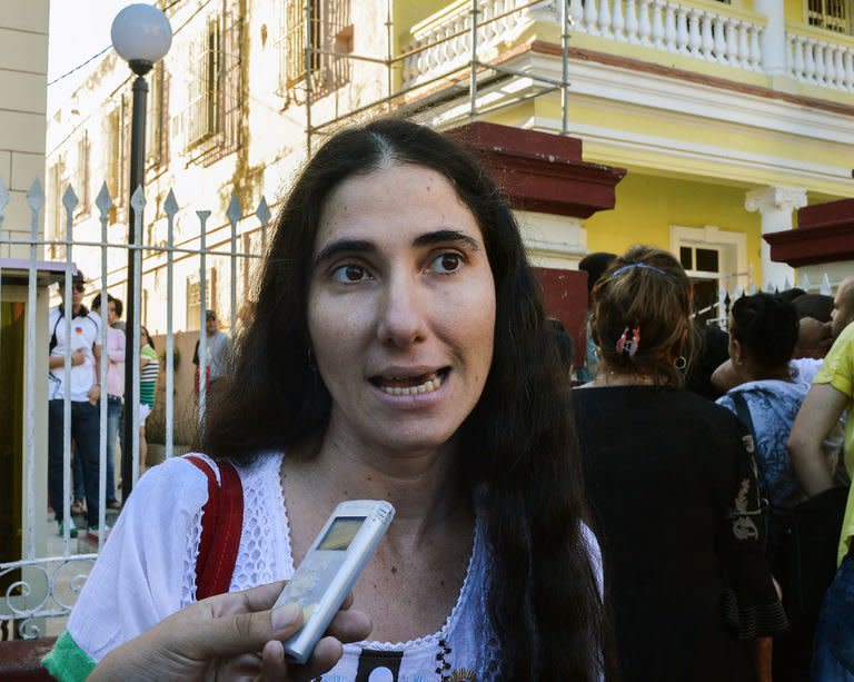 Cuban opposition blogger Yoani Sanchez speaks with the press outside a Migration Office, on January 14, 2013 in Havana. A law allowing Cubans to travel abroad without special exit visas took effect on the communist-ruled island for the first time in half a century