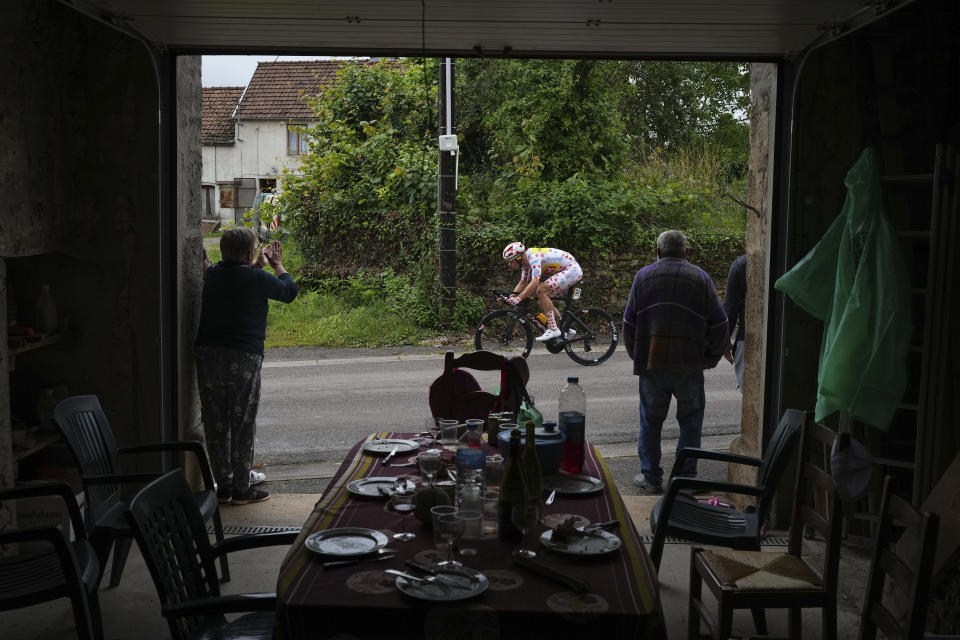 People get up from their table to watch Norway's Jonas Abrahamsen, wearing the best climber's dotted jersey, pass during the eighth stage of the Tour de France cycling race over 183.4 kilometers (114 miles) with start in Semur-en-Auxois and finish in Colombey-les-Deux-Eglises, France, Saturday, July 6, 2024. (AP Photo/Daniel Cole)