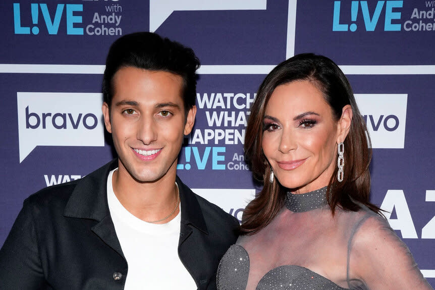 Luann De Lesseps and Joe Bradley smile in front of a step and repeat at the Watch What Happens Live clubhouse in New York City.