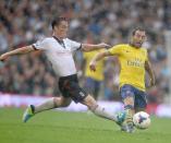 Arsenal's Santi Cazorla gets tackled by Fulham's Scott Parker during the Barclays Premier League match at Craven Cottage, London.