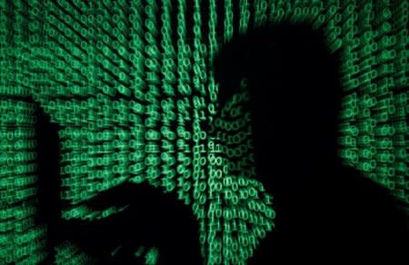 A man holds a laptop computer as cyber code is projected on him in this illustration picture taken on May 13, 2017. REUTERS/Kacper Pempel/Illustration