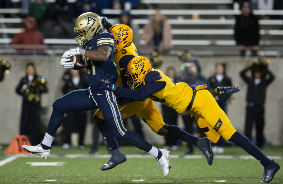 The University of Akron's Lorenzo Lingard powers toward the end zone with Kent State defenders D.J. Miller Jr and Jalani Williams trailing Wednesday night in Akron.