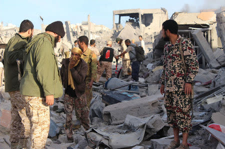 Fighters of Libyan forces allied with the U.N.-backed government gather atop the ruins of a house as they are close to securing last Islamic State holdouts in Sirte, Libya December 5, 2016. REUTERS/Ayman Sahely NO ARCHIVE.