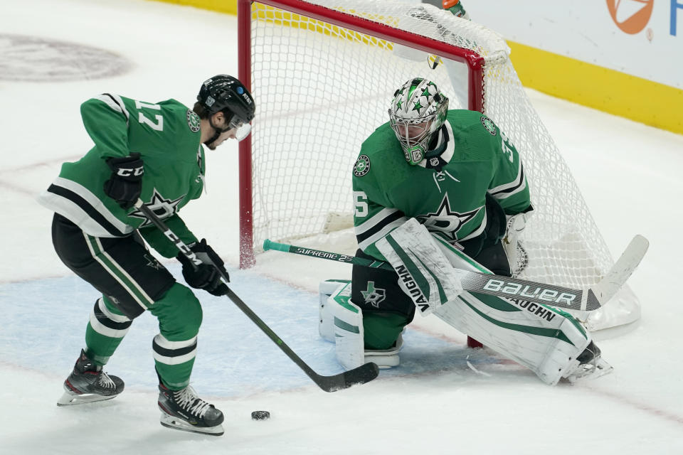 Dallas Stars' Nick Caamano (17) helps clear the puck away from the net as goaltender Anton Khudobin watches during the first period of the team's NHL hockey game against the Nashville Predators in Dallas, Friday, Jan. 22, 2021. (AP Photo/Tony Gutierrez)