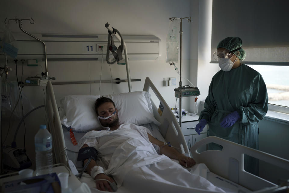 A COVID-19 patient receives treatment in the Hospital del Mar in Barcelona, Spain, Friday, July 9, 2021. After a brief respite that brought its activity back to pre-pandemic routines, the hospital is once again rearranging staff shifts and moving patients around in its sprawling, seafront facilities to face a new surge of infections. (AP Photo/Felipe Dana)