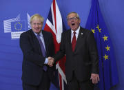 FILE - In this Thursday, Oct. 17, 2019 file photo British Prime Minister Boris Johnson shakes hands with European Commission President Jean-Claude Juncker during a press point at EU headquarters in Brussels. (AP Photo/Francisco Seco)