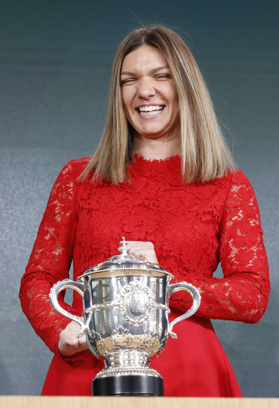 Defending champion Romania's Simona Halep smiles as she poses next to the cup during the draw of the French Open tennis tournament at the Roland Garros stadium in Paris, Thursday, May 23, 2019. The French Open tennis tournament starts Sunday May 26. (AP Photo/Michel Euler)