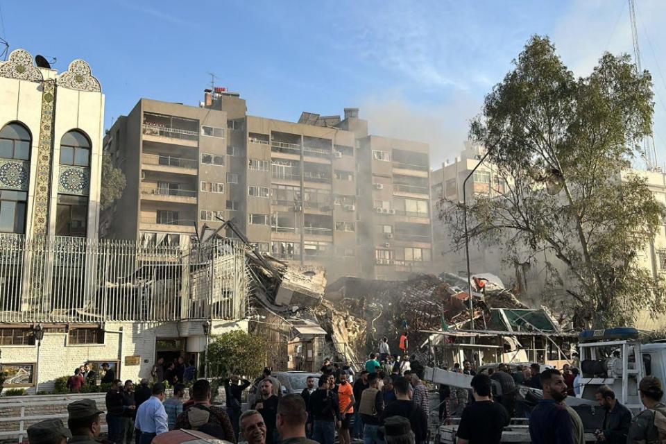Emergency and security personnel gather at the site where a building next to the Iranian embassy in the Syrian capital Damascus was hit on April 1, 2024.