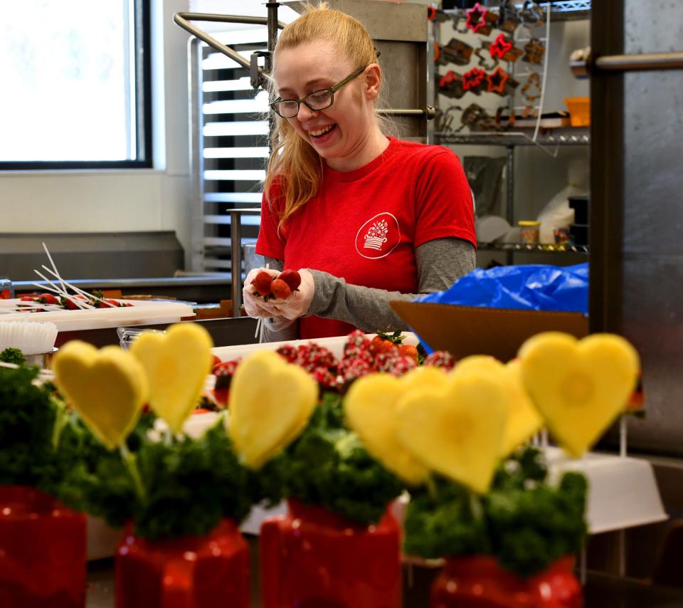 WORCESTER - Edible employee Elizabeth Lovejoy of Worcester prepares strawberries to be dipped in chocolate for an arrangement on Valentine's Day.