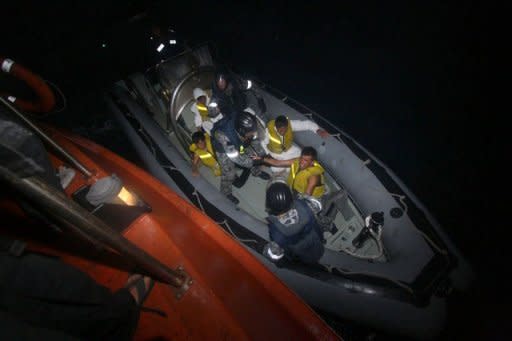 Australian navy personel transfer asylum-seekers to a Indonesian rescue boat near Panaitan island, West Java after the refugee boat sank. Afghans were among the 54 survivors from an asylum-seeker boat that disappeared two days ago off the Indonesian coast, but hopes of finding about 100 more missing were fading fast