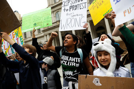 Students hold banners and placards during a demonstration against climate change in New York, U.S., March 15, 2019. REUTERS/Shannon Stapleton