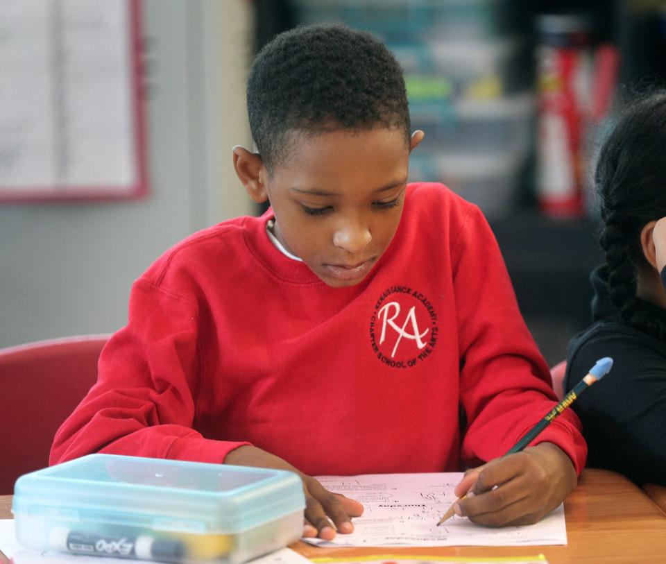 Brian Chervany, a 3rd-grader at Renaissance Academy Charter School, does some class work at the beginning of the school day.