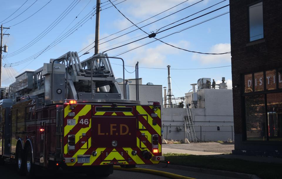 Members of the Lansing Fire Department work at the scene of a fire Tuesday, Aug. 9, 2022, near the intersection of North Larch Street and East Michigan Avenue.