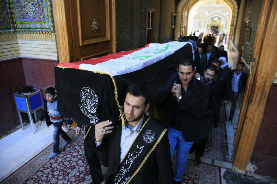 Mourners carry a coffin draped with an Iraqi flag of a man killed in a car bomb on a commercial street in the northern town of Tuz Khormato, during the funeral in the Shiite holy city of Najaf, Iraq, Friday, Feb. 7, 2014. Last year, the country saw the highest death toll since the worst of the country's sectarian bloodletting began to subside in 2007, according to United Nations figures. The U.N. said violence killed 8,868 last year in Iraq. (AP Photo/Jaber al-Helo)