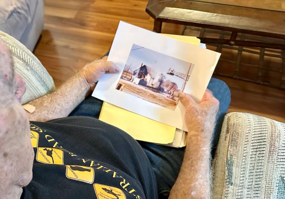 Kingsville resident Wayne Izsak looks at a printout of an image taken when his home in Essex was destroyed by a fire in March 2021. Photographed in Izsak's temporary accommodations on Sept. 15, 2023.