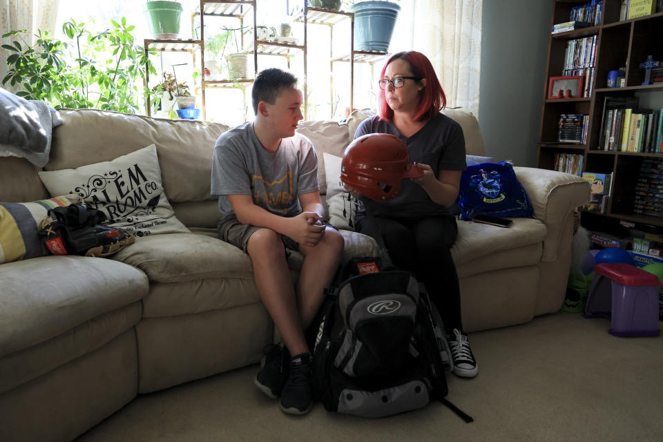 Liam Kennedy, left, and his mother, Rachel, go through an equipment bag while being interviewed Friday, Oct. 28, 2022, in Monroe, Ohio. (AP Photo/Aaron Doster)
