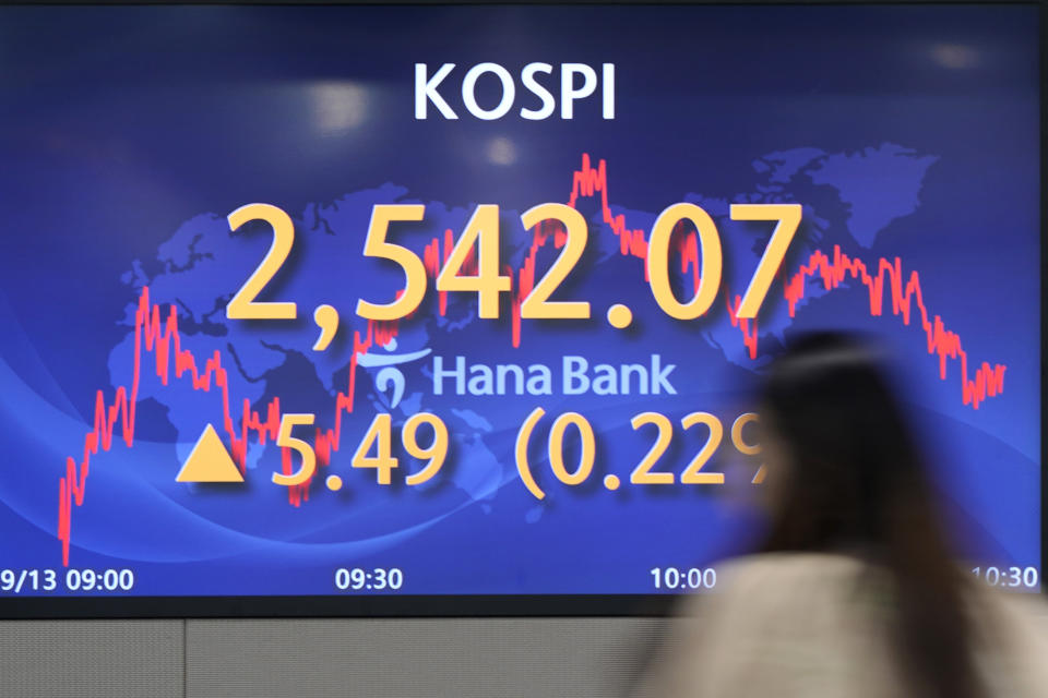An employee of a bank walks by the screens showing the Korea Composite Stock Price Index (KOSPI), left, and the foreign exchange rate between U.S. dollar and South Korean won at a foreign exchange dealing room in Seoul, South Korea, Wednesday, Sept. 13, 2023. Stocks fell Wednesday in Asia after a slide for technology stocks dragged Wall Street lower ahead of a key report on U.S. inflation. (AP Photo/Lee Jin-man)