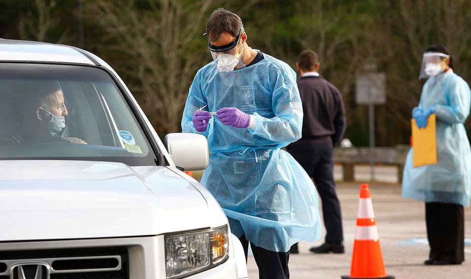 Hanover firefighter/paramedic Thomas Duggan takes a sample from a resident at a drive-thru COVID test site for residents on Thursday, Dec. 10, 2020.