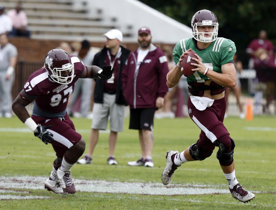 Mississippi State White Team quarterback Nick Fitzgerald (17) looks for an open receiver as Maroon Team defensive lineman Johnathan Calvin (97) closes in during their spring NCAA college football game, Saturday, April 18, 2015, in Starkville, Miss. White won 28-24. (AP Photo/Rogelio V. Solis)