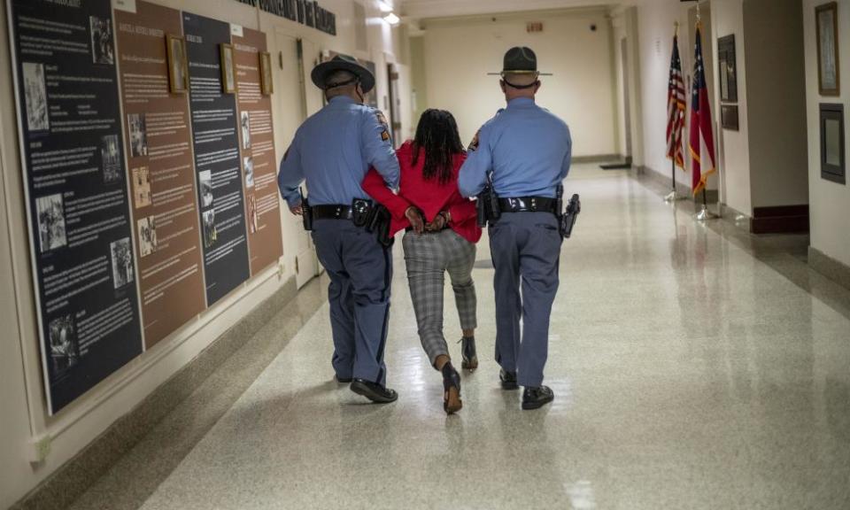 Representative Park Cannon is escorted out of the Georgia capitol building by state troopers after being asked to stop knocking on a door while Governor Brian Kemp was signing SB 202 behind closed doors on 25 March 2021.