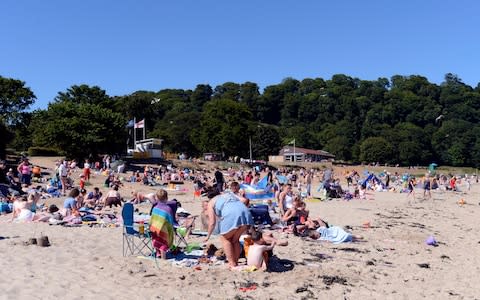 People enjoy the sun on Silver Sands beach at the start of the Scottish school holiday - Credit: Ken Jack - Corbis