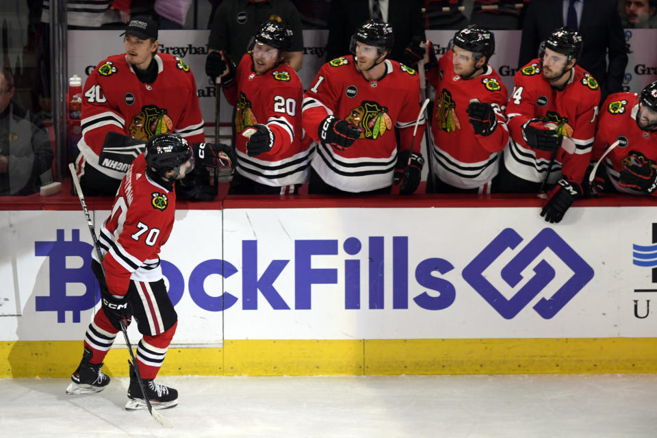 Chicago Blackhawks' Cole Guttman (70) celebrates with teammates at the bench after scoring a goal during the first period of an NHL hockey game against the San Jose Sharks Tuesday, Jan 16, 2024, in Chicago. (AP Photo/Paul Beaty)