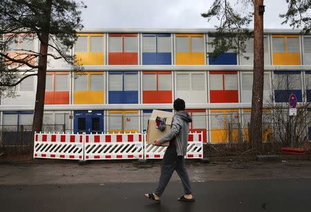 A resident walks in front of a new a refugee centre to house asylum seekers in the Koepenick district of Berlin January 2, 2015. Six new container camps for refugees are to be built in the capital. REUTERS/Fabrizio Bensch