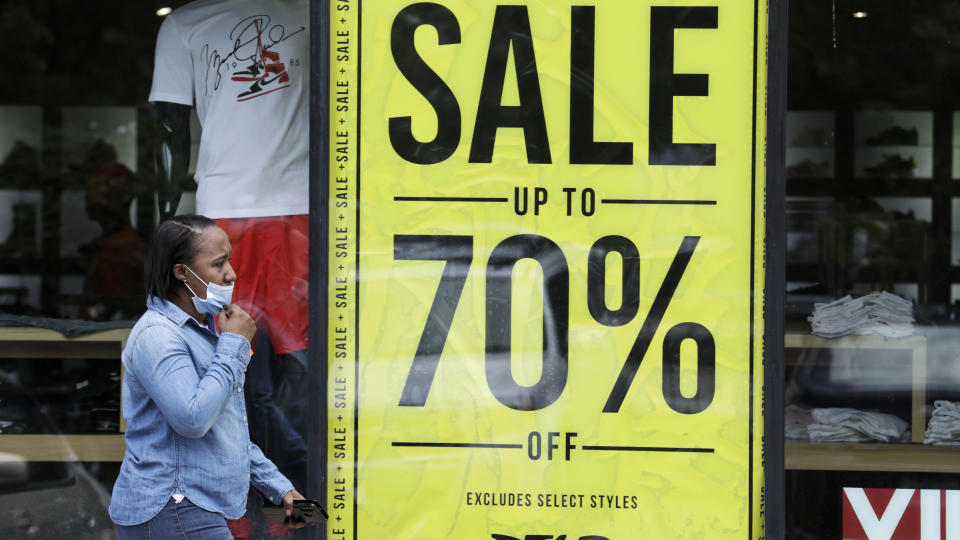 A woman walks past a store advertising sales at 70 percent off, Thursday, May 21, 2020, in Cleveland. More than 2.4 million people applied for U.S. unemployment benefits last week in the latest wave of layoffs from the viral outbreak that triggered widespread business shutdowns two months ago and sent the economy into a deep recession. (AP Photo/Tony Dejak)