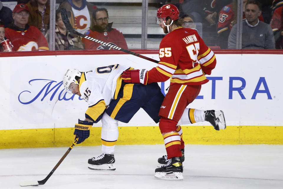 Nashville Predators' Matt Duchene, left, is checked by Calgary Flames' Noah Hanifin during the third period of an NHL hockey game in Calgary, Alberta, Thursday, Nov. 3, 2022. (Larry MacDougal/The Canadian Press via AP)