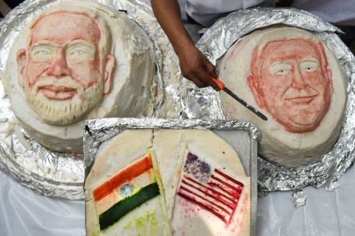 An Indian idli, savoury rice cake, decorated in the image of US President Donald Trump, gets the final touch beside a cake with the image of Indian Prime Minister Narendra Modi -- honoring Trump's first official visit to the world's biggest democracy