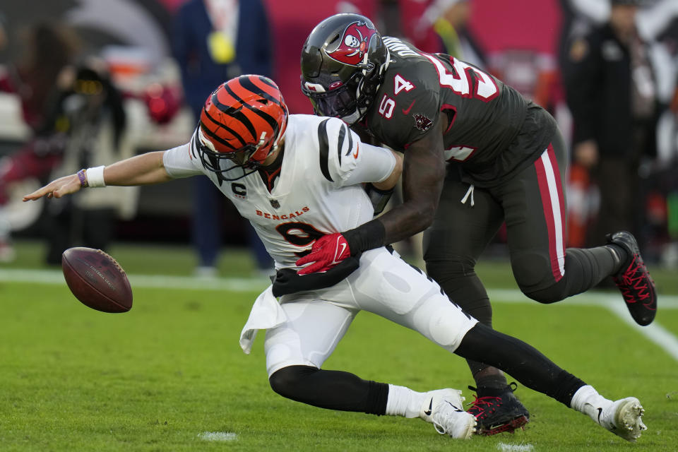 Cincinnati Bengals quarterback Joe Burrow (9) fumbles after being hit by Tampa Bay Buccaneers linebacker Lavonte David (54) during the first half of an NFL football game, Sunday, Dec. 18, 2022, in Tampa, Fla. Burrow recovered his fumble. (AP Photo/Chris O'Meara)