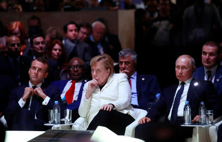 French President Emmanuel Macron, German Chancellor Angela Merkel and Russian President Vladimir Putin attend the opening session of the Paris Peace Forum as part of the commemoration ceremony for Armistice Day, 100 years after the end of the First World War, in Paris, France, November 11, 2018. REUTERS/Gonzalo Fuentes/Pool