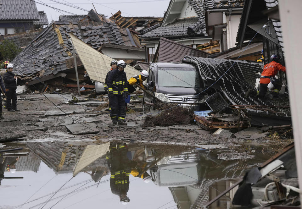 Firefighters search collapsed houses hit by earthquakes in Suzu, Ishikawa prefecture, Japan Wednesday, Jan. 3, 2024. Rescue workers and canine units urgently sifted through rubble Wednesday ahead of predicted freezing cold and heavy rain in what the prime minister called a race against time after powerful earthquakes in western Japan killed multiple people. Dozens are believed trapped under collapsed buildings.(Kyodo News via AP)