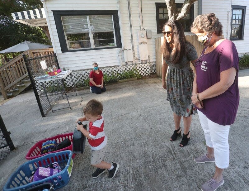 Sasha Staton talks with Kim Vukelja, owner and director of the Imagination Station child care center, while Nash Staton, 3, puts his lunchbox in his class's basket. Many women, including domestic abuse survivors, are struggling to pay for child care during the COVID-19 pandemic.