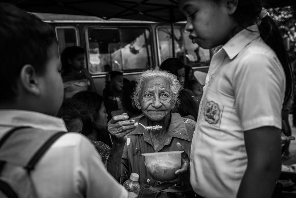 A grandmother feeds her grandchild at a charity kitchen run by volunteers and the NGO Caracas Mi Convive in East Caracas.