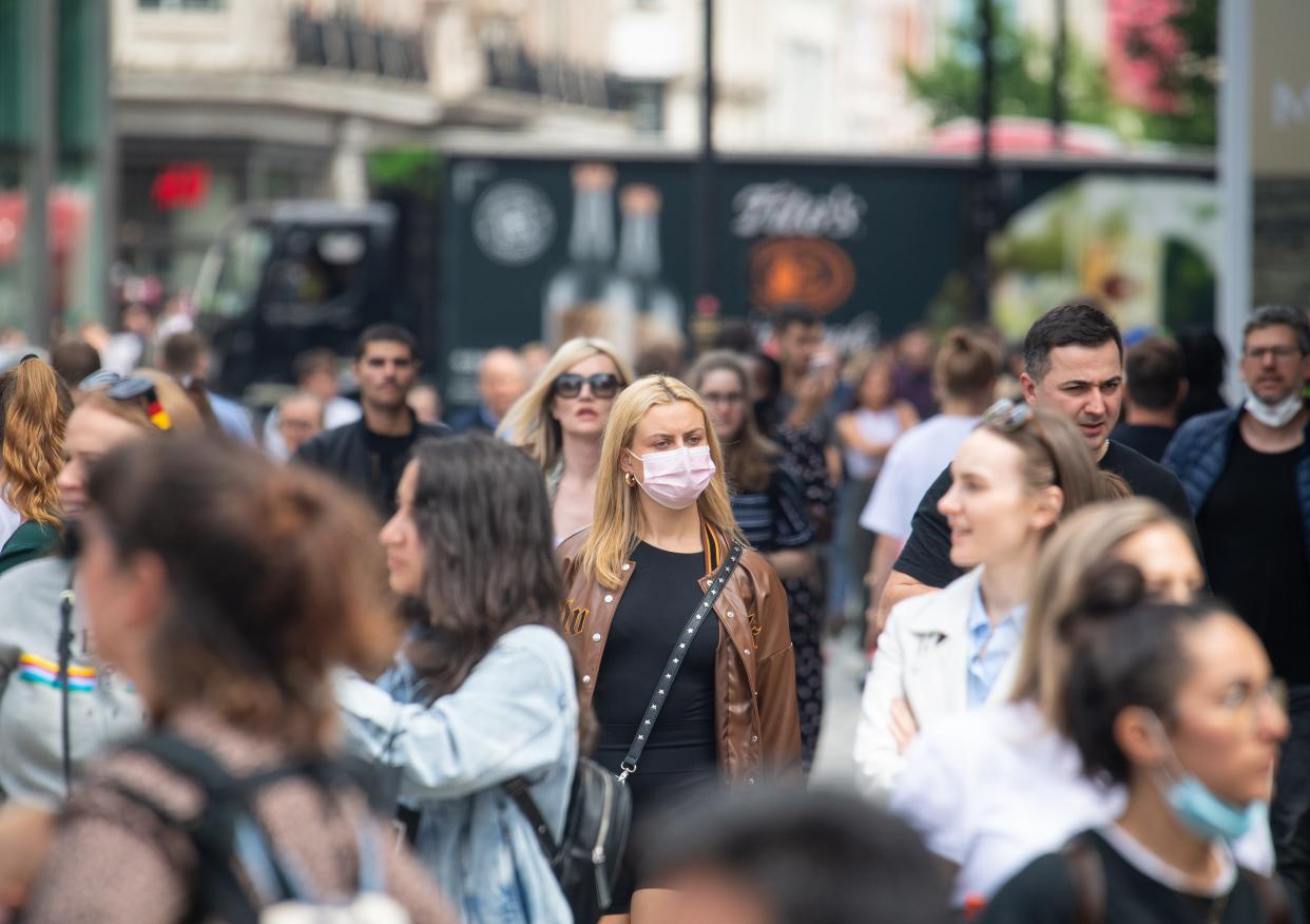 A woman wearing a face mask among a crowd of pedestrians on Oxford Street, (PA) (PA Wire)