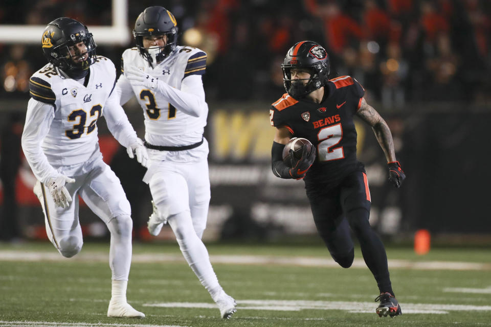 Oregon State wide receiver Anthony Gould (2) runs past California safety Daniel Scott (32) and wide receiver Kenden Robinson Jr. for a touchdown off of a punt return during the first half of an NCAA college football game on Saturday, Nov 12, 2022, in Corvallis, Ore. (AP Photo/Amanda Loman)