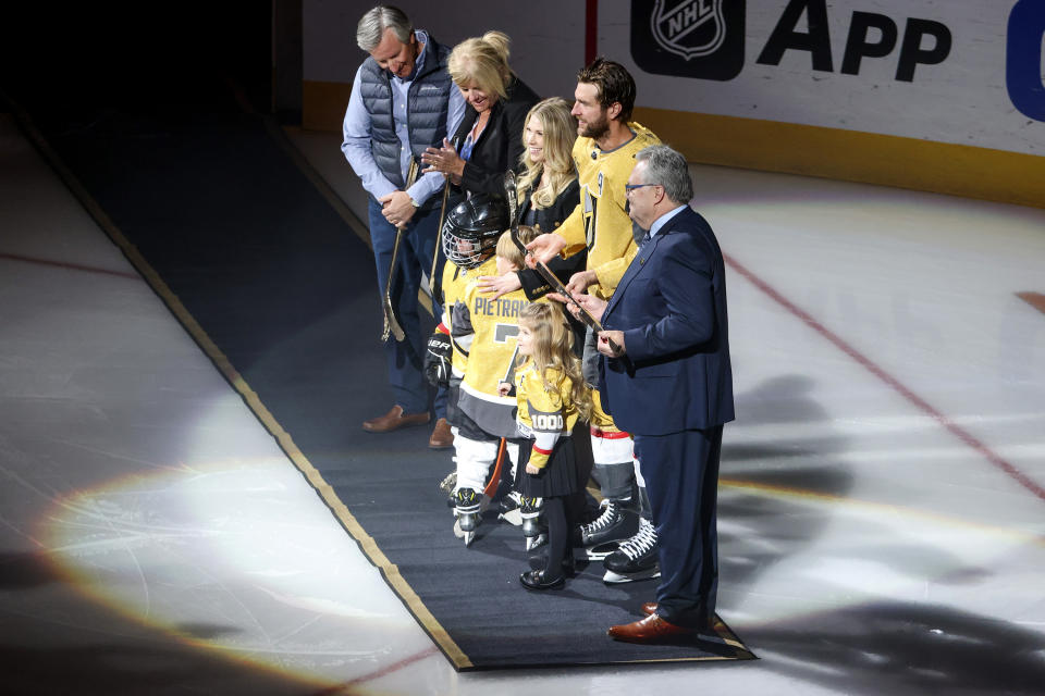 Vegas Golden Knights defenseman Alex Pietrangelo (7) is presented with a golden hockey stick honoring his 1000th NHL game by Golden Knights general manager Kelly McCrimmon, right, during a ceremony prior to an NHL hockey game against the Minnesota Wild, Monday, Feb. 12, 2024, in Las Vegas. (AP Photo/Ian Maule)