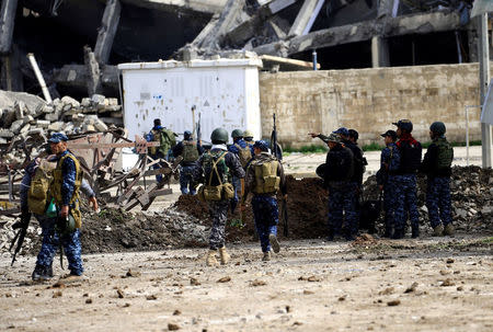 Federal police members carry their weapons as they attempt to break into the Old City during a battle against Islamic State militants, in Mosul, Iraq March 19, 2017. REUTERS/Thaier Al-Sudani