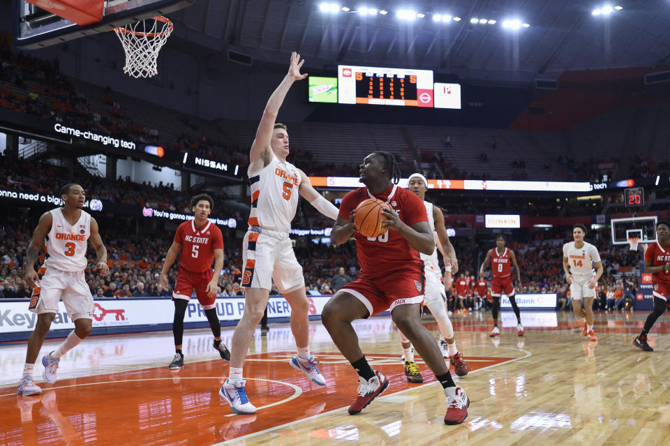 North Carolina State forward DJ Burns, Jr., right, is defended by Syracuse guard Justin Taylor during the first half of an NCAA college basketball game in Syracuse, N.Y., Tuesday, Feb. 14, 2023. (AP Photo/Adrian Kraus)