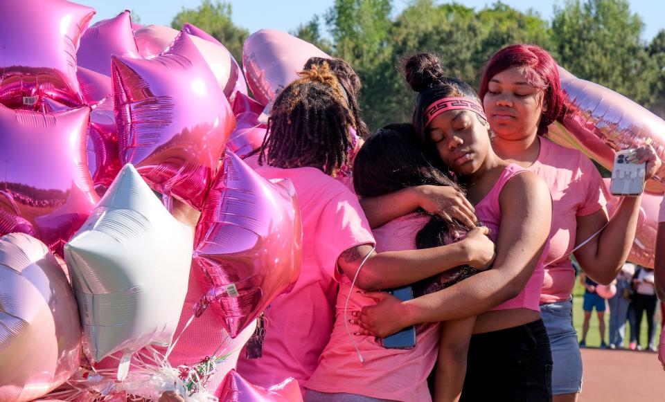 Friends comfort each other as students at Paul Bryant High gather and release balloons in memory of their classmate, Madison Sims, who was killed in a car wreck. 