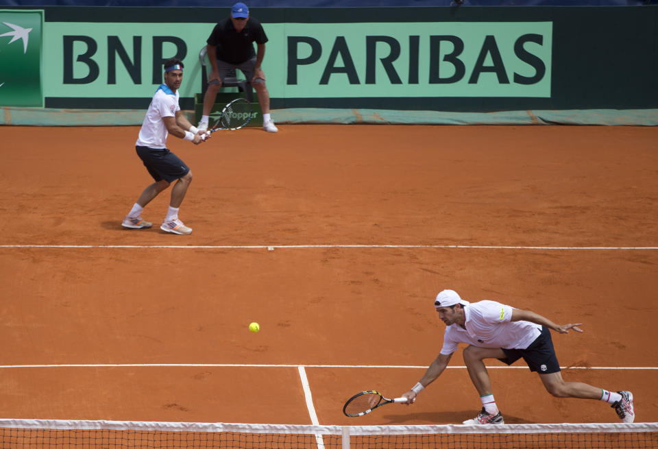 Italy's Simone Bolelli, right, returns the ball to Argentina's doubles team Horacio Zeballos and Eduardo Schwank as his teammate Fabio Fognini look on at left during their Davis Cup doubles match in Mar del Plata, Argentina, Saturday, Feb. 1, 2014. (AP Photo/Eduardo Di Baia)