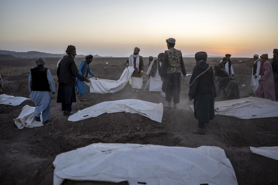 Afghans bury hundreds of people killed in an earthquake at a burial site, outside a village in Zenda Jan district in Herat province, western of Afghanistan, Monday, Oct. 9, 2023. Saturday's deadly earthquake killed and injured thousands when it leveled an untold number of homes in Herat province. (AP Photo/Ebrahim Noroozi)