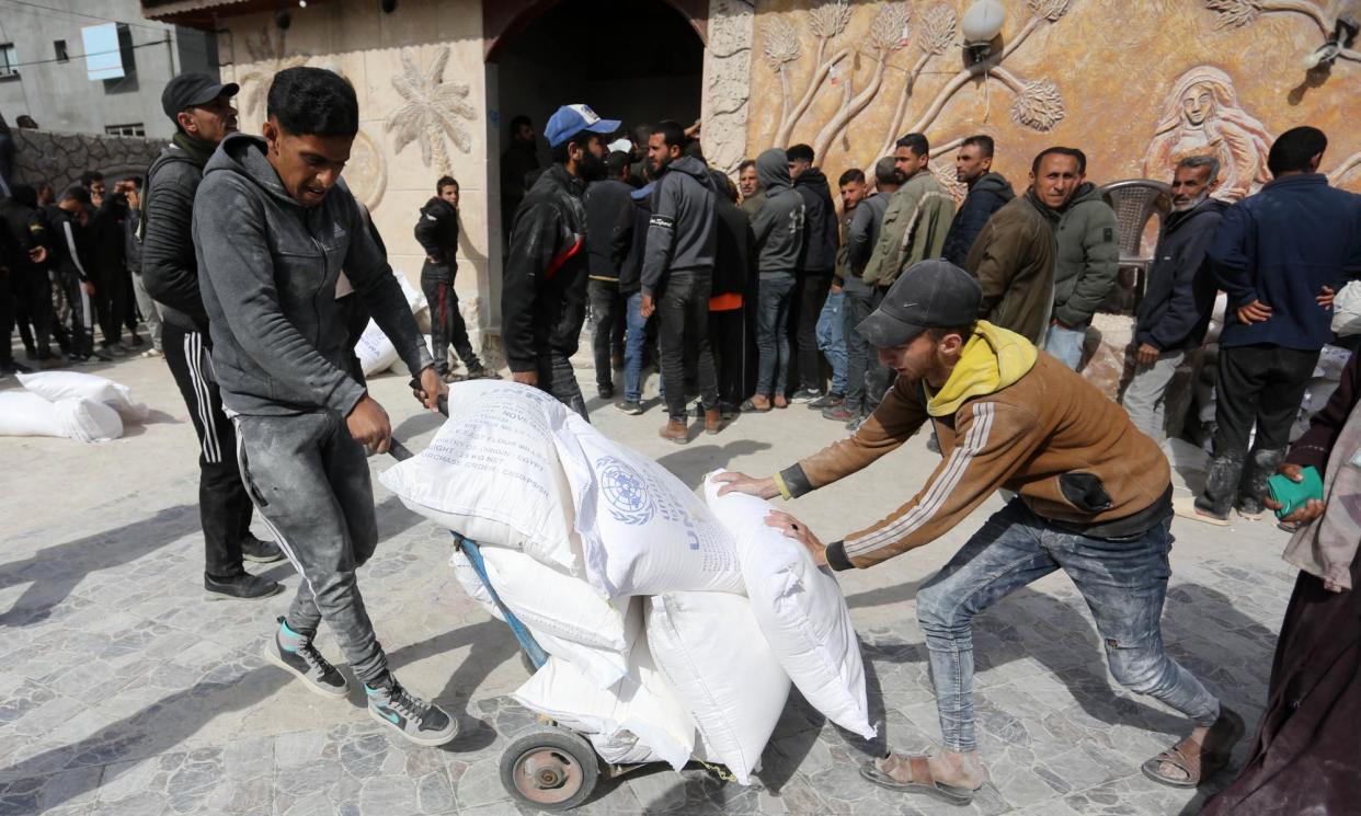 <span>People receive flour distributed by a UN aid agency in Deir al-Balah on Sunday.</span><span>Photograph: Anadolu/Getty Images</span>