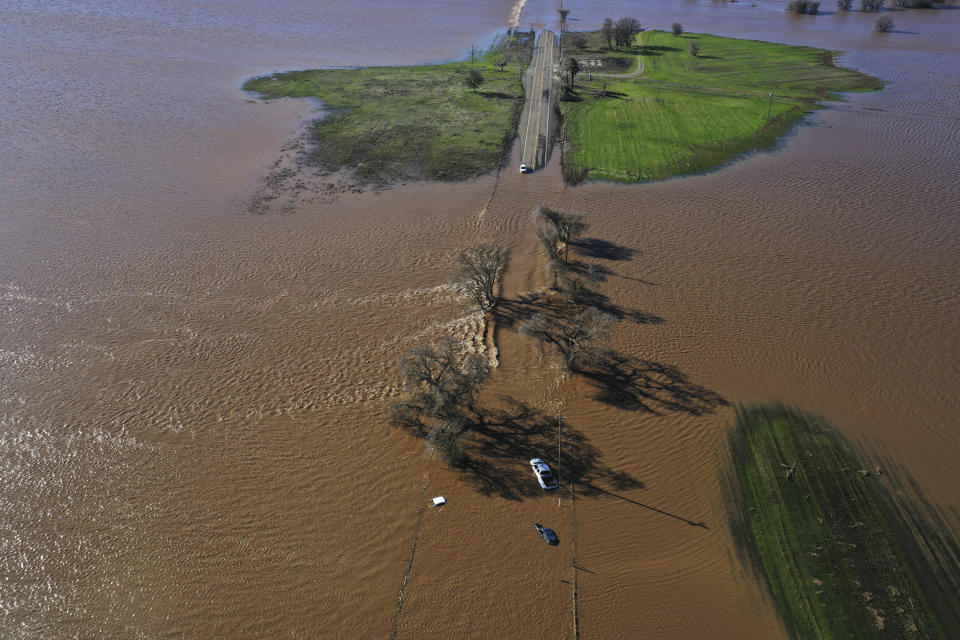 Three vehicles are submerged on Dillard Road west of Highway 99 in south Sacramento County in Wilton, Calif., Sunday, Jan. 1, 2023, after heavy rains on New Year's Eve produced levee breaks. Saturday's system was warmer and wetter, while storms this week will be colder, said Hannah Chandler-Cooley, a meteorologist at the National Weather Service in Sacramento. The Sacramento region could receive a total of 4 to 5 inches (10 to 13 centimeters) of rain over the week, Chandler-Cooley said. (Hector Amezcua/The Sacramento Bee via AP)