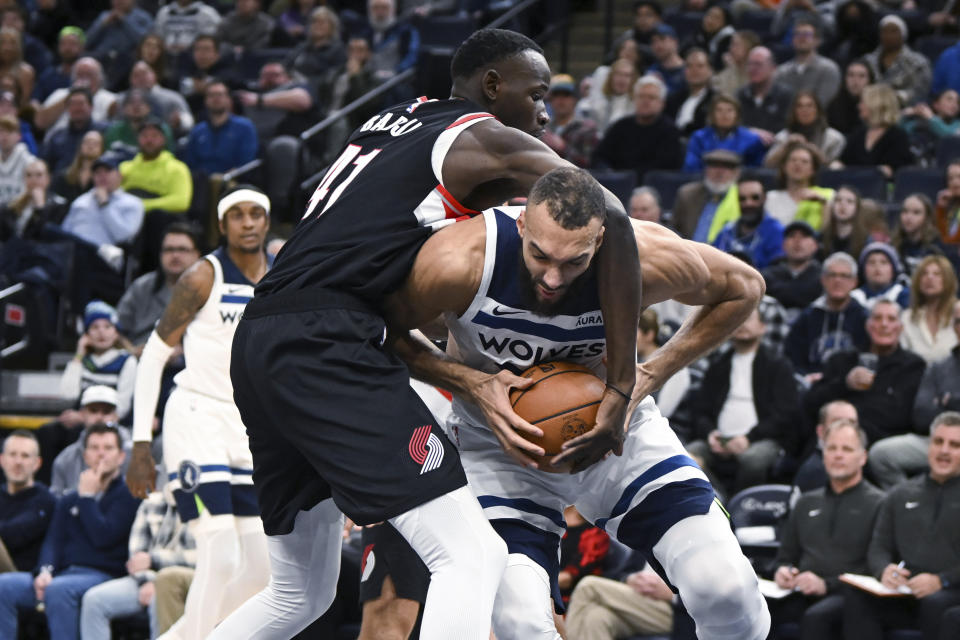 Minnesota Timberwolves center Rudy Gobert, right, is fouled by Portland Trail Blazers center Ibou Badji during the first half of an NBA basketball game Friday, Jan. 12, 2024, in Minneapolis. (AP Photo/Craig Lassig)