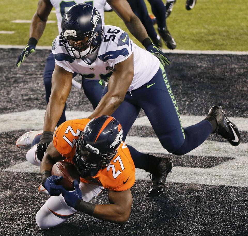 Denver Broncos running back Knowshon Moreno (27) recovers a fumble against Seattle Seahawks defensive end Cliff Avril (56) in the end zone after a bad snap in the first half of the NFL Super Bowl XLVIII football game against the Seattle Seahawks, Sunday, Feb. 2, 2014, in East Rutherford, N.J. A safety was ruled on the play. (AP Photo/Kathy Willens)