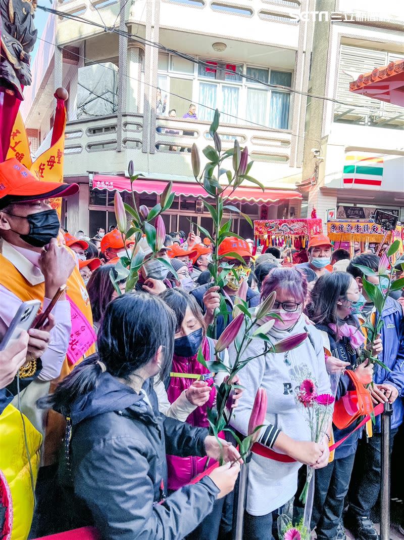 拱天宮外突然有人送百合花，不少信眾拿到很驚喜。（圖／記者鄭尹翔攝影）