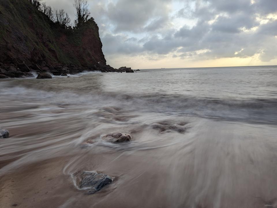 Sunrise beach with long exposure effect blurring the ocean water movement